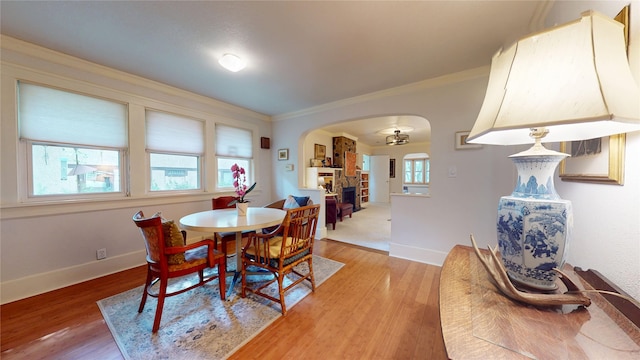 3827 Carpenter Ave, Des Moines, IA 50311 - dining room with arched walkways, light wood finished floors, and ornamental molding