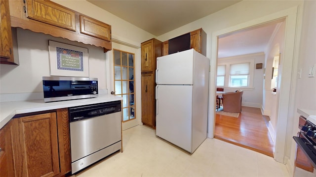 3827 Carpenter Ave, Des Moines, IA 50311 - kitchen with stainless steel appliances, brown cabinets, light countertops, and light floors