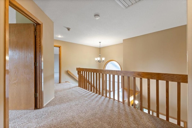 704 SW Coventry Cir, Ankeny, IA 50023 - hallway with carpet flooring, an upstairs landing, and a chandelier