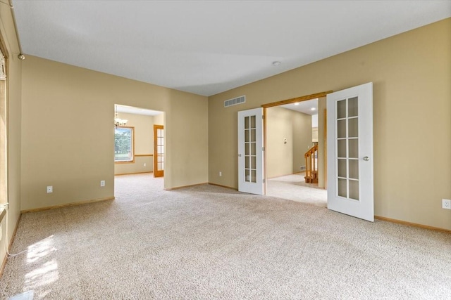 704 SW Coventry Cir, Ankeny, IA 50023 - empty room with french doors, light carpet, and a chandelier