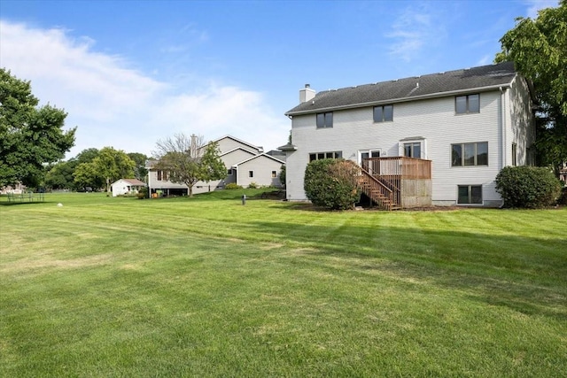 704 SW Coventry Cir, Ankeny, IA 50023 - back of property with stairs, a chimney, a yard, and a deck