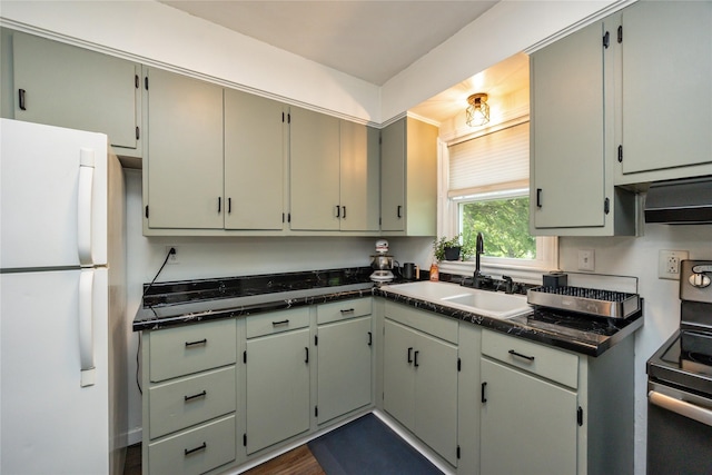 4207 Madison Ave, Des Moines, IA 50310 - kitchen featuring freestanding refrigerator, electric stove, dark countertops, and exhaust hood