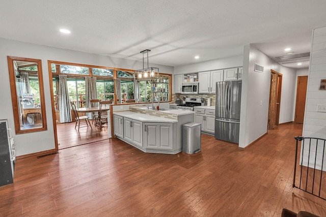 1018 S 5th St, Knoxville, IA 50138 - kitchen with appliances with stainless steel finishes, light countertops, healthy amount of natural light, dark wood-style floors, and recessed lighting
