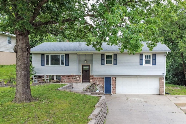 1018 S 5th St, Knoxville, IA 50138 - split foyer home with concrete driveway, an attached garage, a front yard, and brick siding
