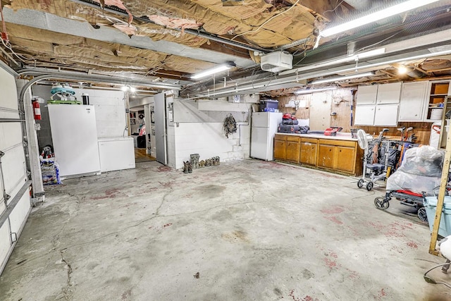 1018 S 5th St, Knoxville, IA 50138 - garage with freestanding refrigerator, a garage door opener, and washer / dryer