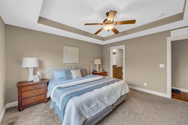 2501 NE Ewing Ct, Grimes, IA 50111 - bedroom featuring a raised ceiling, carpet, a ceiling fan, and ensuite bath