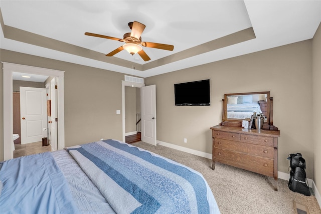 2501 NE Ewing Ct, Grimes, IA 50111 - carpeted bedroom with a raised ceiling, ceiling fan, and ensuite bathroom