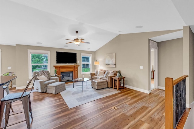 2501 NE Ewing Ct, Grimes, IA 50111 - living area with light wood-style floors, ceiling fan, a glass covered fireplace, and lofted ceiling