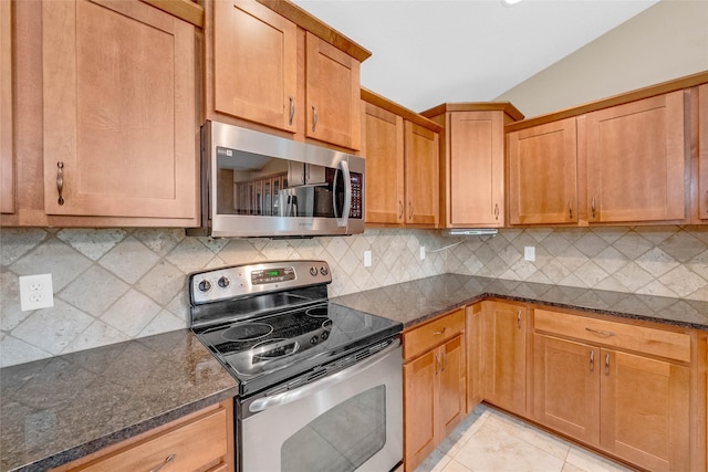 2501 NE Ewing Ct, Grimes, IA 50111 - kitchen featuring appliances with stainless steel finishes, backsplash, dark stone countertops, and lofted ceiling