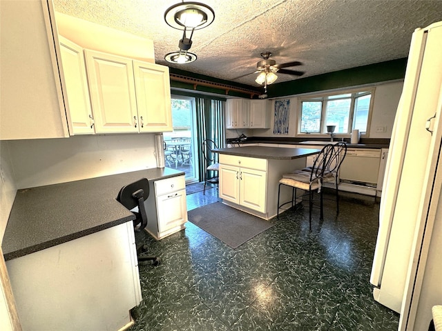 3419 E 37th St, Des Moines, IA 50317 - kitchen with dark countertops, built in study area, ceiling fan, dark floors, and a textured ceiling