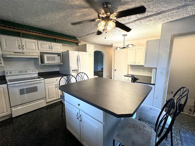 3419 E 37th St, Des Moines, IA 50317 - kitchen featuring white appliances, dark countertops, arched walkways, white cabinetry, and a textured ceiling