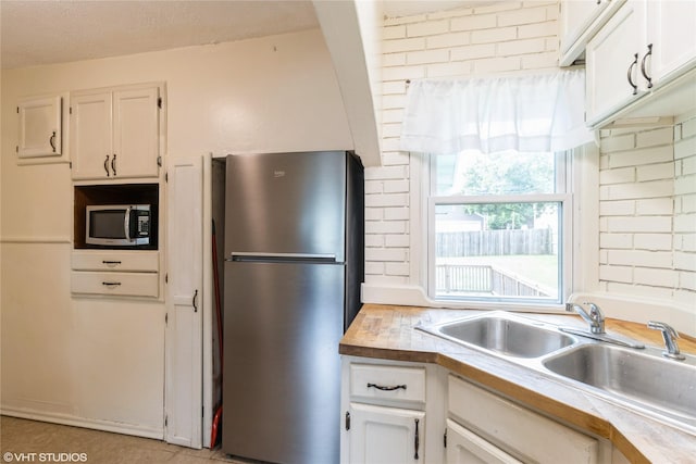 4512 Hickman Rd, Des Moines, IA 50310 - kitchen featuring appliances with stainless steel finishes, white cabinetry, and light countertops