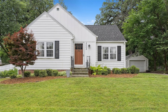 4004 Franklin Ave, Des Moines, IA 50310 - view of front of home with board and batten siding, entry steps, a front yard, a shingled roof, and an outbuilding