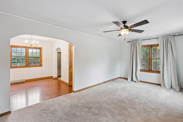 4004 Franklin Ave, Des Moines, IA 50310 - carpeted empty room with arched walkways, ceiling fan, a chandelier, and ornamental molding