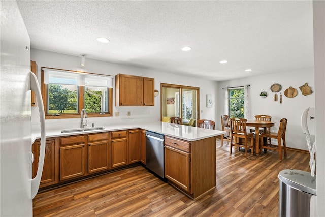 9421 NE 28th Ct, Ankeny, IA 50021 - kitchen featuring dishwasher, freestanding refrigerator, a peninsula, brown cabinets, and recessed lighting