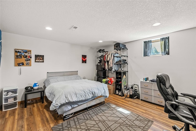 9421 NE 28th Ct, Ankeny, IA 50021 - bedroom featuring light wood finished floors, a textured ceiling, recessed lighting, and a desk