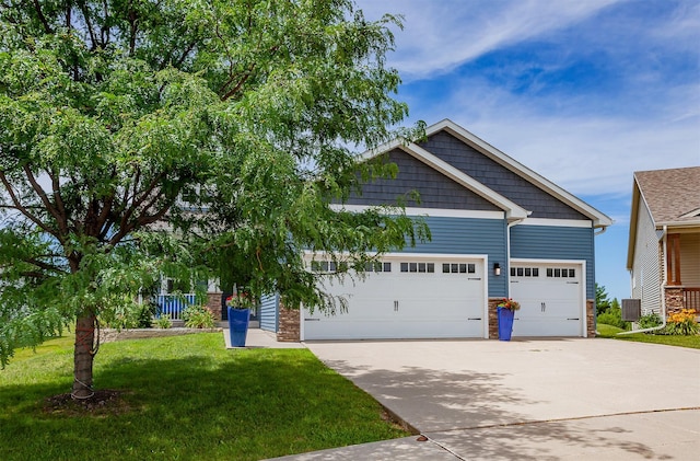 938 15th St SE, Altoona, IA 50009 - craftsman-style home featuring driveway, a front lawn, a garage, and stone siding