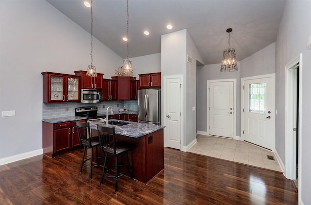 938 15th St SE, Altoona, IA 50009 - kitchen featuring appliances with stainless steel finishes, dark brown cabinets, a chandelier, high vaulted ceiling, and dark wood-type flooring