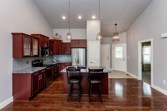938 15th St SE, Altoona, IA 50009 - kitchen with appliances with stainless steel finishes, high vaulted ceiling, dark brown cabinets, a center island with sink, and backsplash