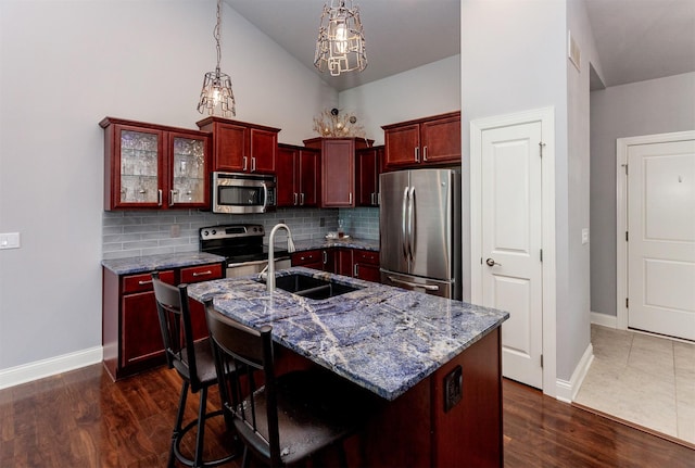 938 15th St SE, Altoona, IA 50009 - kitchen featuring appliances with stainless steel finishes, dark brown cabinets, backsplash, a chandelier, and dark stone countertops
