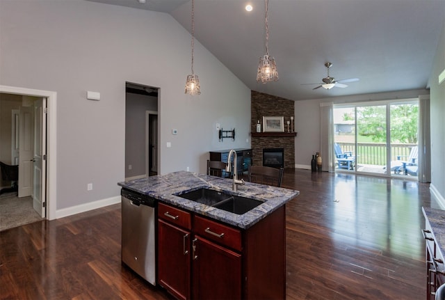938 15th St SE, Altoona, IA 50009 - kitchen with stainless steel dishwasher, dark brown cabinets, ceiling fan, a stone fireplace, and a kitchen island with sink