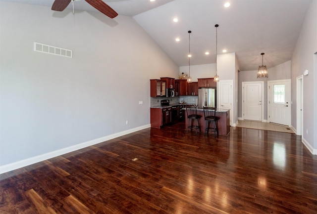 938 15th St SE, Altoona, IA 50009 - kitchen with appliances with stainless steel finishes, high vaulted ceiling, a breakfast bar area, a kitchen island, and a ceiling fan