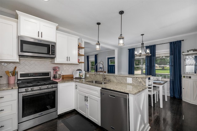 2610 Westover Blvd, Des Moines, IA 50322 - kitchen featuring appliances with stainless steel finishes, a peninsula, dark wood-style flooring, white cabinets, and crown molding