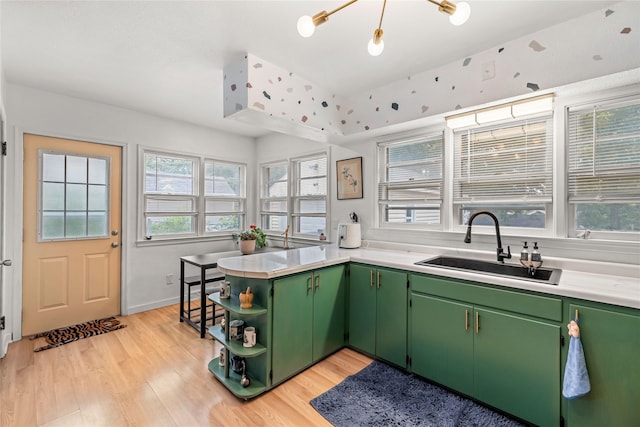 1416 Clinton Ave, Des Moines, IA 50313 - kitchen featuring green cabinets, open shelves, a peninsula, light wood finished floors, and light countertops