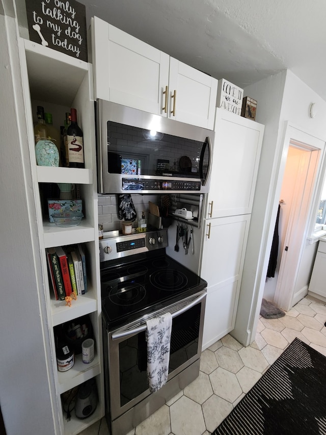2904 48th St, Des Moines, IA 50310 - kitchen with appliances with stainless steel finishes, white cabinets, backsplash, light tile patterned flooring, and open shelves