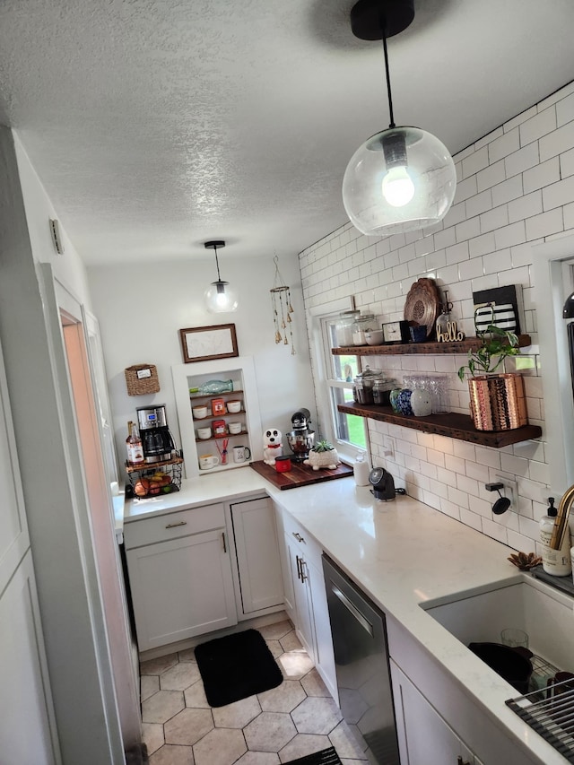2904 48th St, Des Moines, IA 50310 - kitchen with stainless steel dishwasher, light tile patterned floors, a textured ceiling, light countertops, and open shelves