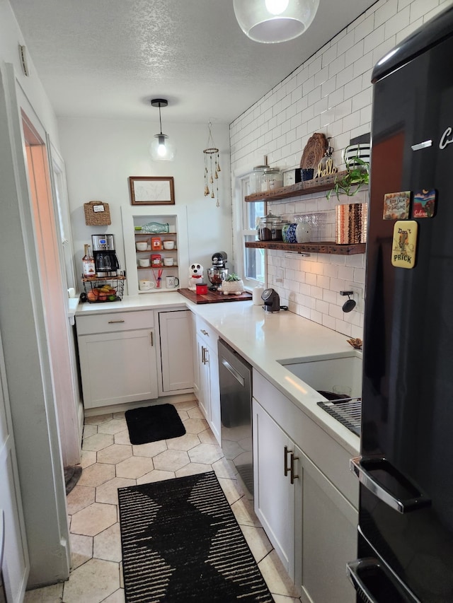 2904 48th St, Des Moines, IA 50310 - kitchen featuring black fridge, stainless steel dishwasher, tasteful backsplash, light countertops, and a textured ceiling