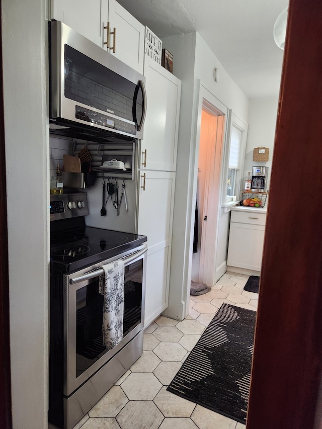 2904 48th St, Des Moines, IA 50310 - kitchen with stainless steel appliances, white cabinetry, and light tile patterned flooring