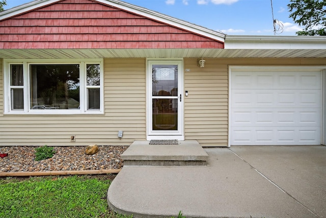 8026 Crestview Dr, Des Moines, IA 50320 - doorway to property featuring concrete driveway and a garage