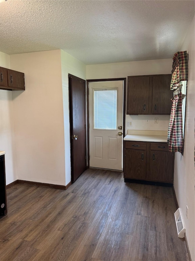 435 E Watrous Ave, Des Moines, IA 50315 - kitchen featuring dark wood-style floors, dark brown cabinetry, light countertops, and a textured ceiling