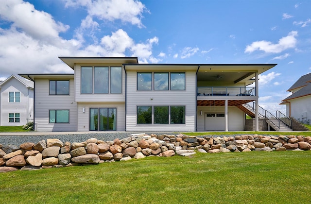 605 S Tiburon Cv, West Des Moines, IA 50266 - back of property featuring stairway, a lawn, an attached garage, and a wooden deck