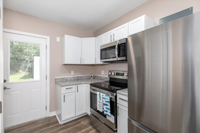 2311 Williams St, Des Moines, IA 50317 - kitchen featuring stainless steel appliances, white cabinetry, dark wood-style flooring, and a textured ceiling