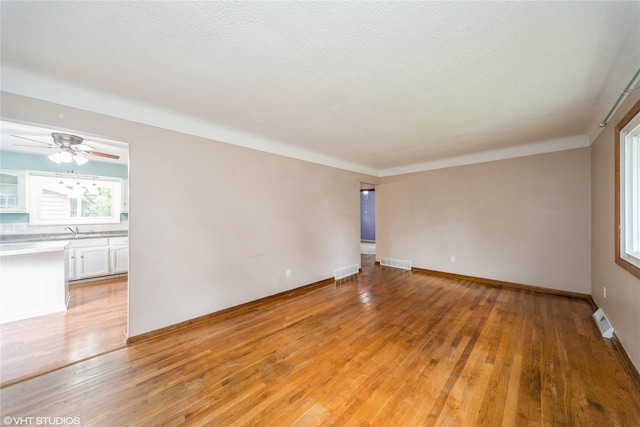 214 SW Scott St, Ankeny, IA 50023 - spare room featuring light wood finished floors, a textured ceiling, and ceiling fan