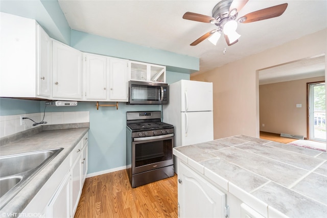 214 SW Scott St, Ankeny, IA 50023 - kitchen featuring appliances with stainless steel finishes, white cabinetry, light wood-style flooring, and a ceiling fan