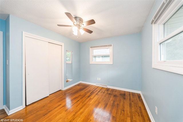 214 SW Scott St, Ankeny, IA 50023 - unfurnished bedroom featuring wood-type flooring, a closet, and ceiling fan