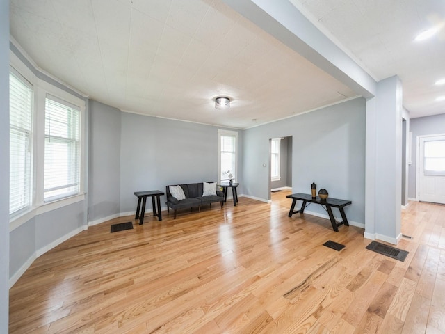 1534 9th St, Des Moines, IA 50314 - sitting room with light wood finished floors, healthy amount of natural light, and ornamental molding
