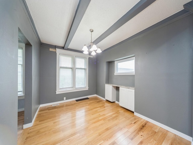 1534 9th St, Des Moines, IA 50314 - empty room with a chandelier, beam ceiling, light wood-style flooring, and a textured ceiling