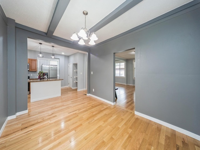 1534 9th St, Des Moines, IA 50314 - unfurnished living room with a chandelier, light wood-style floors, and beamed ceiling