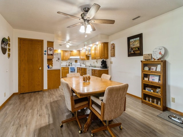 1439 N Shore Dr, Knoxville, IA 50138 - dining space with light wood finished floors and a ceiling fan