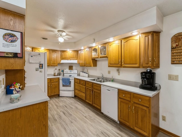 1439 N Shore Dr, Knoxville, IA 50138 - kitchen featuring white appliances, brown cabinets, a ceiling fan, under cabinet range hood, and light countertops
