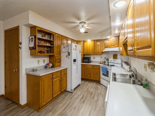1439 N Shore Dr, Knoxville, IA 50138 - kitchen with white appliances, under cabinet range hood, light wood-style floors, a ceiling fan, and brown cabinetry