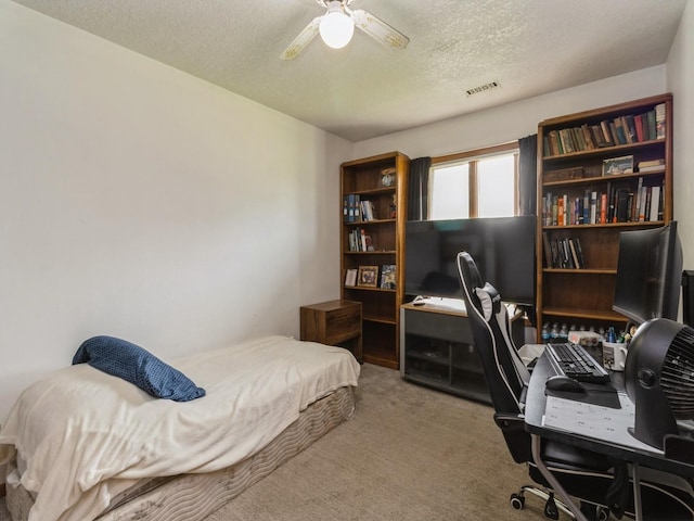 1439 N Shore Dr, Knoxville, IA 50138 - carpeted bedroom with a textured ceiling, an office area, and a ceiling fan