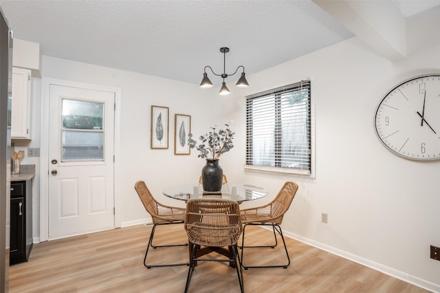 3600 E 42nd Ct, Des Moines, IA 50317 - dining area with light wood finished floors, a chandelier, and a textured ceiling