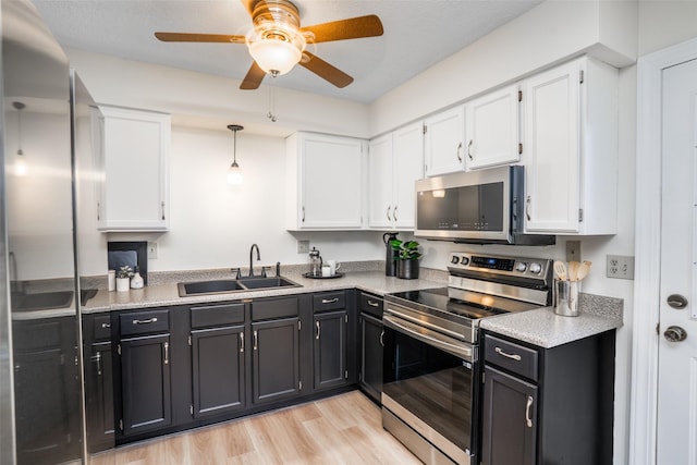3600 E 42nd Ct, Des Moines, IA 50317 - kitchen featuring stainless steel appliances, white cabinets, and dark cabinets