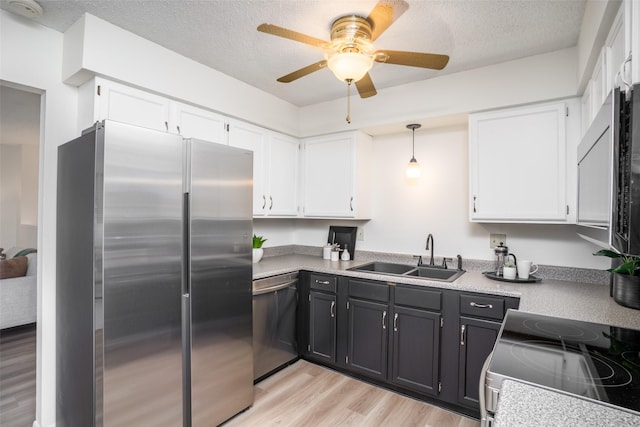 3600 E 42nd Ct, Des Moines, IA 50317 - kitchen with appliances with stainless steel finishes, white cabinetry, ceiling fan, and a textured ceiling