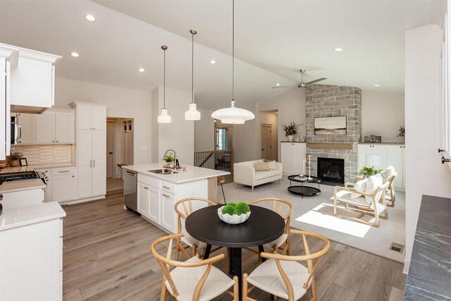 519 16th Avenue Ct SE, Altoona, IA 50009 - kitchen with ceiling fan, light wood-style floors, light countertops, vaulted ceiling, and a center island with sink